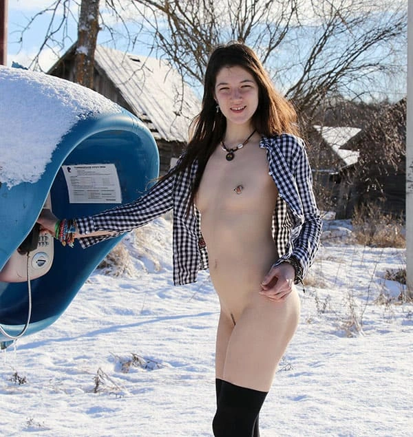 Молодая девушка  зимой гуляет по деревне без трусов