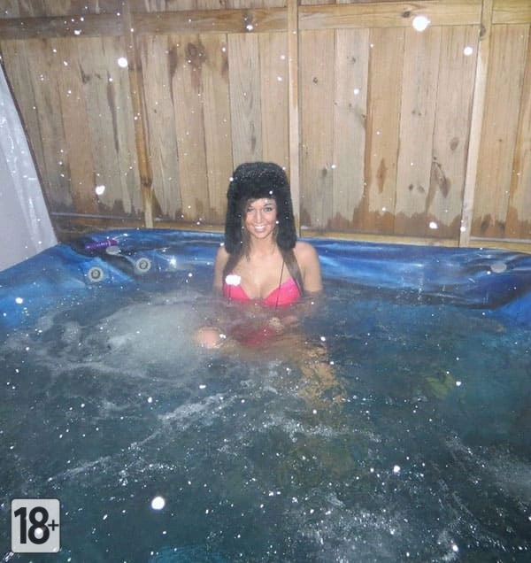 Девушка в горячем джакузи зимой в ушанке