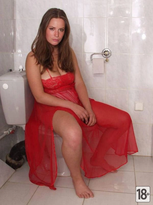 Милфа с большими сиськами позирует голая на унитазе